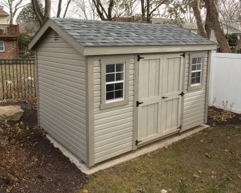 Beige A-frame shed with a gray roof.