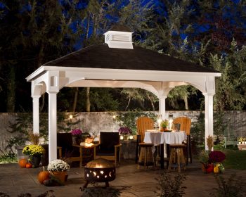Traditional white vinyl pavilion with a cupola roof on a patio in the evening.