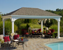 Traditional white vinyl pavilion on a brick patio by the pool.