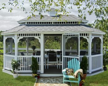 Oval white vinyl gazebo with a pagoda roof in a backyard.