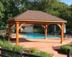 14' x 20' Grand Estate Pine Pavilion on a patio by a pool.