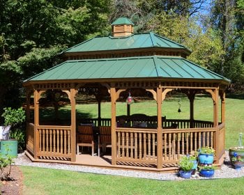 Oval New England style gazebo with a green pagoda roof in a backyard.