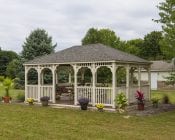 Country style ivory vinyl gazebo in a backyard.