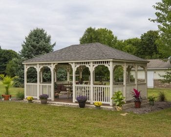 Country style ivory vinyl gazebo in a backyard.