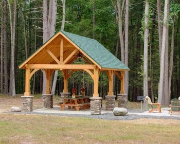 Alpine cedar wood pavilion with picnic benches underneath.