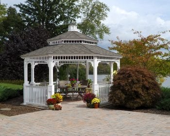 White Octagonal country style vinyl gazebo with a pagoda roof and no floor on a brick patio.