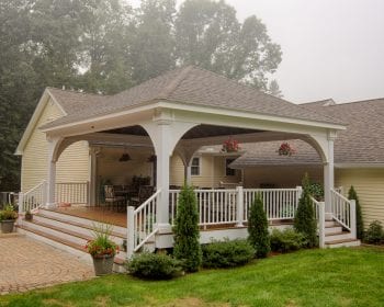 White vinyl grand estate pavilion with asphalt shingles on a back porch.